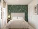 Comfortable bedroom with floral accent wall, neutral bedding, and natural light at 13252 Sw 85Th Cir # 58, Ocala, FL 34473