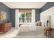 Serene bedroom with blue walls, natural light, wooden dresser, stylish lamps, and comfortable bedding at 13252 Sw 85Th Cir # 58, Ocala, FL 34473