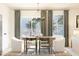 Bright dining area featuring a modern chandelier, stylish chairs, and large windows with palm tree views at 13252 Sw 85Th Cir # 58, Ocala, FL 34473
