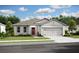 Charming single-story home with a gray exterior, red door, attached garage, and well-manicured lawn at 13252 Sw 85Th Cir # 58, Ocala, FL 34473