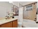 Bathroom with a tub and shower combo, single sink vanity, wood cabinets, and decorative wall art at 1389 Longley Place, Deland, FL 32724