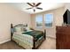 Well lit bedroom boasts two windows, a ceiling fan, and wooden furniture at 14486 Sunbridge Cir, Winter Garden, FL 34787