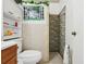 Bathroom features a stone-look shower, tile walls, and a faux window at 14884 Sw 35Th Cir, Ocala, FL 34473