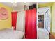 A small bedroom with closet access behind curtains, and yellow walls at 14884 Sw 35Th Cir, Ocala, FL 34473