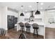 Bright kitchen featuring stainless steel appliances, a center island with barstool seating and wood flooring at 17087 Wynford Ln, Winter Garden, FL 34787