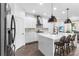Kitchen with white cabinets, a center island with seating, and modern pendant lighting at 17087 Wynford Ln, Winter Garden, FL 34787