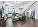 Bright living area with a modern sectional, hardwood floors, and tall windows with lots of light at 17087 Wynford Ln, Winter Garden, FL 34787
