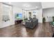 Living room featuring a comfortable sectional, hardwood floors, large windows, and modern decor at 17087 Wynford Ln, Winter Garden, FL 34787