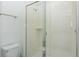 Clean bathroom featuring white tiled shower with glass door, toilet, and bright modern design at 2145 Fleming Mist Pl, Kissimmee, FL 34747
