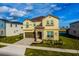 Beautiful two story home featuring manicured lawn, stone details, two-car garage and a covered entryway at 2145 Fleming Mist Pl, Kissimmee, FL 34747