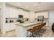Bright kitchen boasts stainless steel appliances, white cabinetry, island with breakfast bar and tile floors at 2145 Fleming Mist Pl, Kissimmee, FL 34747