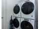 Modern laundry room featuring stacked white Whirlpool washer and dryer units and a compact vacuum cleaner at 2145 Fleming Mist Pl, Kissimmee, FL 34747