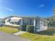 Well maintained home featuring bright white siding, an enclosed porch, manicured shrubs, and tidy landscaping at 223 Pinewood Dr, Eustis, FL 32726
