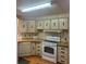 Functional kitchen featuring light wood cabinets, laminate countertops, and essential appliances for efficient meal preparation at 223 Pinewood Dr, Eustis, FL 32726