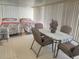 Enclosed lanai featuring two twin beds, a table, and ample natural light offering a versatile space for relaxation at 223 Pinewood Dr, Eustis, FL 32726
