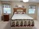 Comfortable main bedroom featuring a decorative headboard, floral accents, and neutral carpet providing a peaceful retreat at 223 Pinewood Dr, Eustis, FL 32726