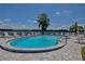 Community pool overlooking a lake features a spacious sundeck with lounge chairs and tables at 223 Pinewood Dr, Eustis, FL 32726