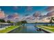 Waterfront property featuring a boat slip with covered boat lift, landscaping and gorgeous sunset view at 223 Pinewood Dr, Eustis, FL 32726