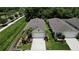 A high angle shot of the home, with a manicured lawn, two-car garage, mature landscaping, and adjacent greenery and sidewalk at 2271 Delhi Pl, Sanford, FL 32771