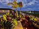 Well-maintained backyard with a pond and fountain view at twilight, enhanced by vibrant landscaping at 2271 Delhi Pl, Sanford, FL 32771