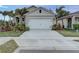 Inviting home with a neatly kept front yard, complemented by lush greenery and a two-car garage at 2271 Delhi Pl, Sanford, FL 32771