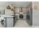 Bright kitchen with gray cabinets, stainless steel appliances and an island with pendant lighting at 2271 Delhi Pl, Sanford, FL 32771