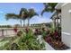 Lush landscaping, including palms, accents the walkway to this home with black fence and a view in the distance at 2271 Delhi Pl, Sanford, FL 32771