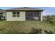 Screened patio, view of large backyard with lush green grass, and mature trees along the black fence at 2271 Delhi Pl, Sanford, FL 32771