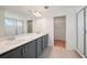 Bathroom boasts double sinks with grey cabinets, tiled floor, walk-in shower, and walk-in closet at 2354 Broadbrook Dr, St Cloud, FL 34771