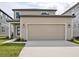 Tan two-story home featuring an attached two-car garage and a well-manicured lawn at 2354 Broadbrook Dr, St Cloud, FL 34771