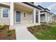 Inviting front porch with columns, manicured landscaping, blue door and sidewalk at 2354 Broadbrook Dr, St Cloud, FL 34771