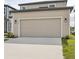 Close-up of a home's two-car garage, showcasing the concrete driveway and lush green grass at 2354 Broadbrook Dr, St Cloud, FL 34771