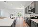 Modern kitchen with stainless steel appliances, gray cabinets, and a large island with a sink and view to the backyard at 2354 Broadbrook Dr, St Cloud, FL 34771