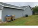Backyard view showing exterior wall with two garbage bins and an air conditioning unit at 236 Bay Head Dr, Kissimmee, FL 34743