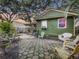 Backyard view with patio, green home exterior, and shaded trees at 2410 E Church St, Orlando, FL 32803