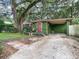 Cozy green home with carport and a driveway covered in leaves at 2410 E Church St, Orlando, FL 32803