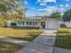 Charming one-story home with a well-manicured lawn, blue shutters, and a paved driveway at 2418 Whitehall Cir, Winter Park, FL 32792