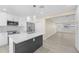 Contemporary kitchen with white cabinets, stainless steel appliances, and an island with a dark base and quartz countertop at 2418 Whitehall Cir, Winter Park, FL 32792