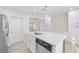 Open kitchen featuring white cabinets, stainless steel appliances, and an island with quartz countertop and bar seating at 2418 Whitehall Cir, Winter Park, FL 32792