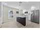 Modern kitchen features white cabinetry, stainless steel appliances, and a dark island with quartz countertop and pendant lighting at 2418 Whitehall Cir, Winter Park, FL 32792