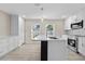 Spacious kitchen with white cabinets, stainless steel appliances, a gray backsplash, and an island with an undermount sink at 2418 Whitehall Cir, Winter Park, FL 32792