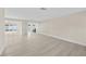 Open concept living space features fresh paint, light wood flooring and a partial view of the kitchen at 2418 Whitehall Cir, Winter Park, FL 32792