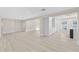 Open-concept living room with hardwood floors and neutral paint, and view into kitchen area at 2418 Whitehall Cir, Winter Park, FL 32792