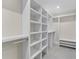 Spacious walk-in closet featuring custom shelving and ample storage space with gray flooring at 2418 Whitehall Cir, Winter Park, FL 32792