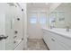 Bright bathroom featuring double vanity sinks, a bathtub and a glass door walk-in shower at 2424 Varenna Loop, Kissimmee, FL 34741