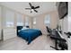 Bright bedroom with large windows, a blue bed, and a functional workspace at 2424 Varenna Loop, Kissimmee, FL 34741