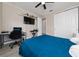 Bedroom featuring a blue quilted bed, desk, and closet at 2424 Varenna Loop, Kissimmee, FL 34741