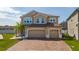 Charming two-story home featuring a three-car garage and a brick paver driveway at 2424 Varenna Loop, Kissimmee, FL 34741