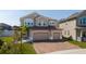 Charming two-story home featuring a three-car garage and a brick paver driveway at 2424 Varenna Loop, Kissimmee, FL 34741