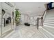 Bright, open-concept living room with tile flooring, modern lighting, and a stylish staircase at 2424 Varenna Loop, Kissimmee, FL 34741